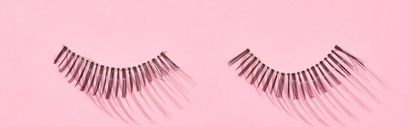 Panoramic shot of black false eyelashes on pink background — Stock Photo