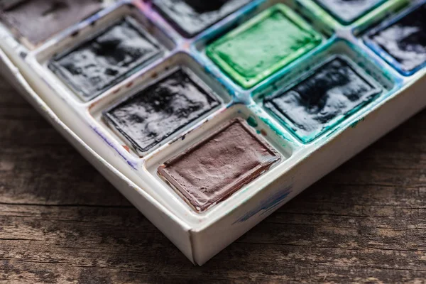 Close up view of watercolor dirty colorful paint palette — Stock Photo