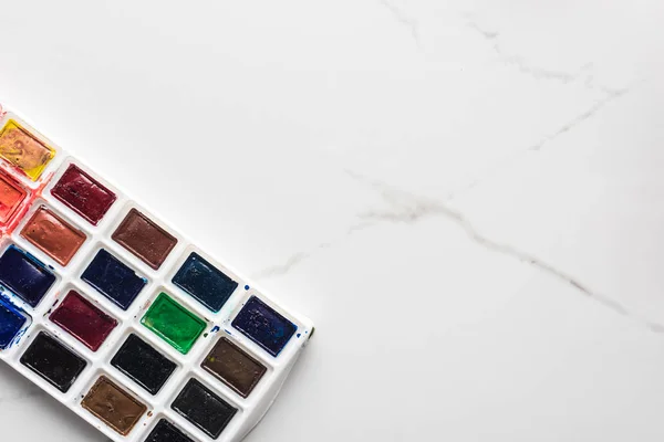 Palette de peinture aquarelle sur marbre surface blanche avec espace de copie — Photo de stock