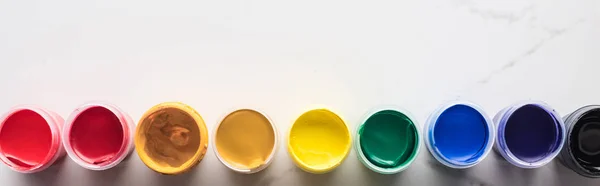 Leigos planos com pinturas guache brilhantes multicoloridas na superfície branca de mármore com espaço de cópia, tiro panorâmico — Fotografia de Stock