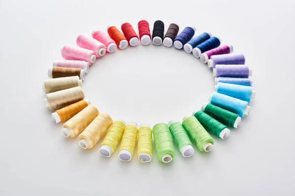 Плоска лежала з яскравими і барвистими нитками на білому тлі — стокове фото