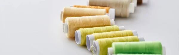 Panoramic shot of bright and colorful threads on white background — Stock Photo