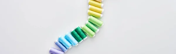 Panoramic shot of bright and colorful threads on white background — Stock Photo