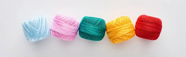 Panoramic shot of bright and colorful knitting yarn balls on white background — Stock Photo