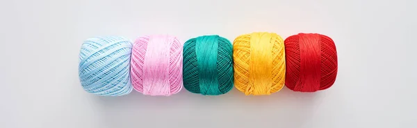 Panoramic shot of bright and colorful knitting yarn balls on white background — Stock Photo