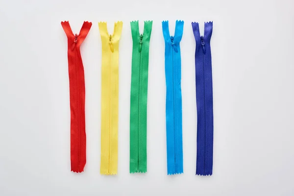 Top view of bright and colorful zippers on white background — Stock Photo