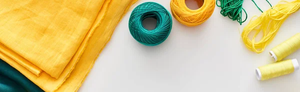 Panoramic shot of fabric, knitting yarn balls and threads on white background — Stock Photo