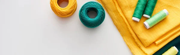 Panoramic shot of fabric, knitting yarn balls and threads on white background — Stock Photo