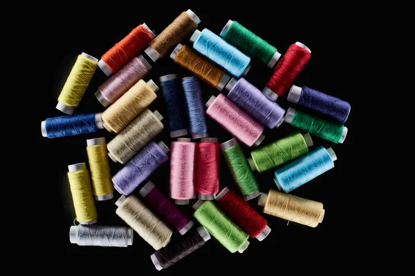 Vista superior de hilos brillantes y coloridos aislados en negro - foto de stock