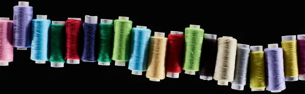 Panoramic shot of bright and colorful threads isolated on black — Stock Photo