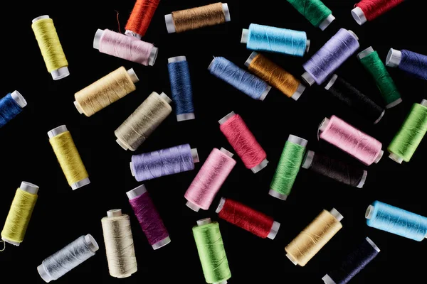 Top view of bright and colorful threads isolated on black — Stock Photo