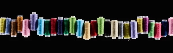 Panoramic shot of bright and colorful threads isolated on black — Stock Photo