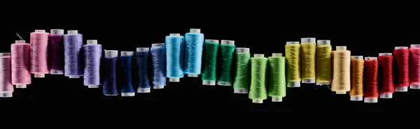 Panoramic shot of bright and colorful threads isolated on black — Stock Photo