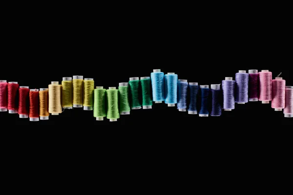 Vista superior de hilos brillantes y coloridos aislados en negro - foto de stock