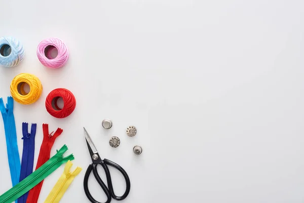 Ansicht von Reißverschlüssen, Scheren, Fingerhüten, Strickgarnbällchen, Spulen auf weißem Hintergrund — Stockfoto