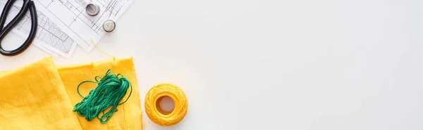 Plan panoramique de ciseaux, dés à coudre, fil, boule de fil à tricoter, tissu et motifs de couture sur fond blanc — Photo de stock