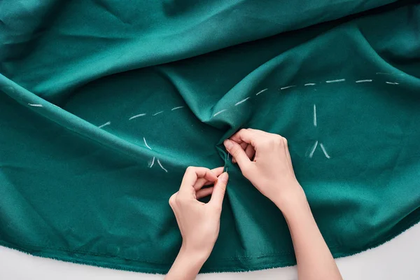 Top view of seamstress sewing colorful fabric with needle on white background — Stock Photo