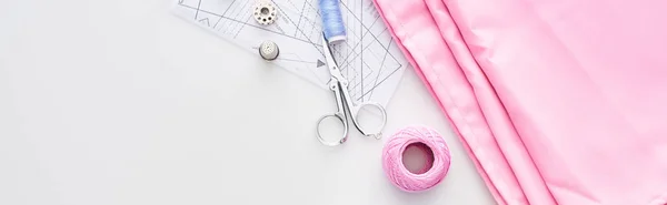 Panoramic shot of fabric, knitting yarn ball, scissors, thimble, bobbin and thread on white background — Stock Photo