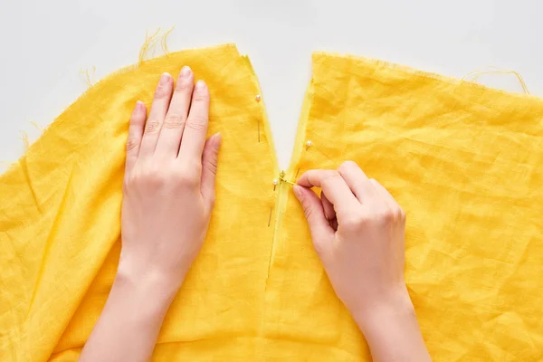 Vista recortada de la mujer cosiendo con aguja sobre fondo blanco — Stock Photo