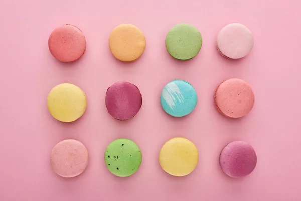 Flat lay with colorful delicious French macaroons on pink background — Stock Photo