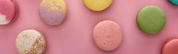 Top view of delicious French macaroons on pink background, panoramic shot — Stock Photo