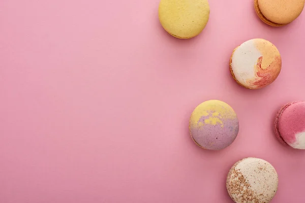 Vista superior de macaroons franceses deliciosos multicoloridos no fundo rosa — Fotografia de Stock