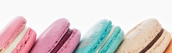 Vista de perto de deliciosos macaroons franceses coloridos de diferentes sabores isolados em branco, tiro panorâmico — Fotografia de Stock