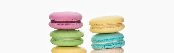 Filas de coloridos macarrones franceses de diferentes sabores aislados en blanco, plano panorámico - foto de stock