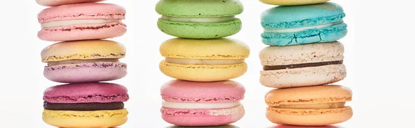 Rows of tasty colorful French macaroons of different flavors isolated on white, panoramic shot — Stock Photo