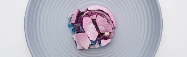 Vista superior de delicioso macarrón francés aplastado púrpura en el plato aislado en blanco, plano panorámico - foto de stock