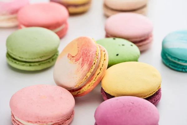 Vista de perto de macaroons franceses coloridos doces de sabores diferentes no fundo branco, tiro panorâmico — Fotografia de Stock