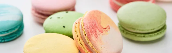 Vista de perto de macaroons franceses doces de sabores diferentes no fundo branco, tiro panorâmico — Fotografia de Stock