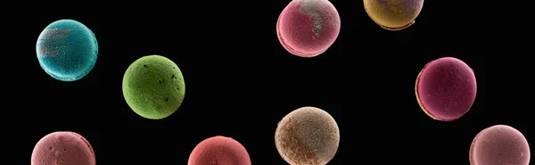 Vista dall'alto di deliziosi macaron francesi colorati di diversi sapori isolati su nero, colpo panoramico — Foto stock