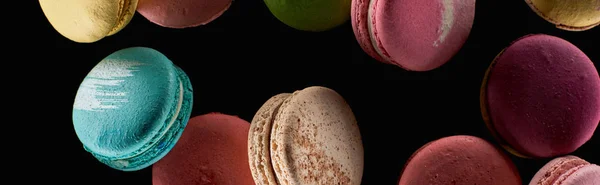 Vue de dessus de macarons français colorés éparpillés de différentes saveurs isolés sur noir, panoramique — Photo de stock