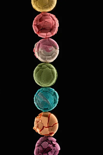 Flat lay with smashed delicious colorful French macaroons of different flavors isolated on black — Stock Photo