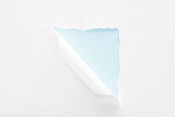 Papier blanc déchiré et laminé sur fond rayé bleu clair — Photo de stock