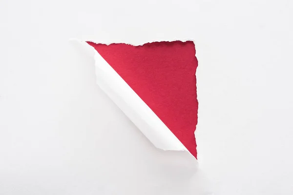 Papier blanc déchiré et laminé sur fond rouge profond — Photo de stock