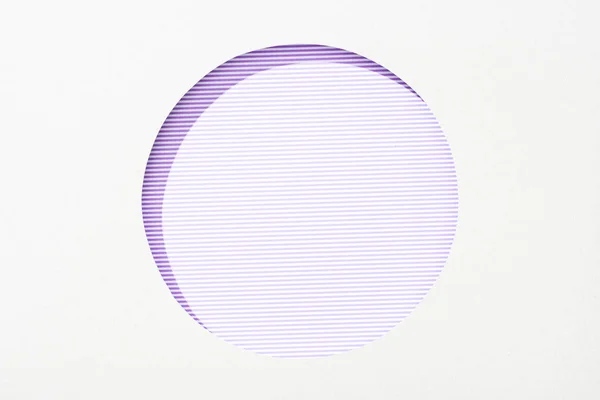 Trou rond découpé en papier blanc sur fond rayé violet et blanc — Photo de stock