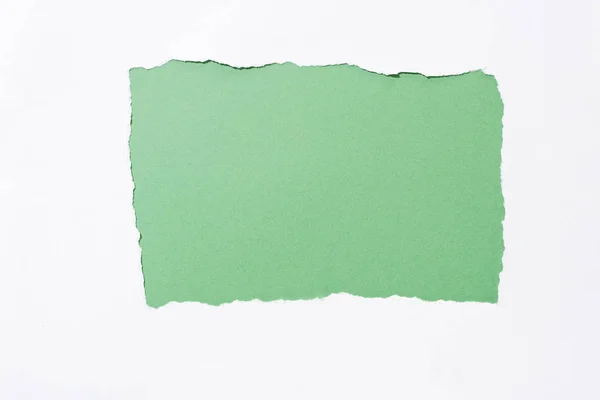 Fond coloré vert dans un trou de papier déchiré blanc — Photo de stock