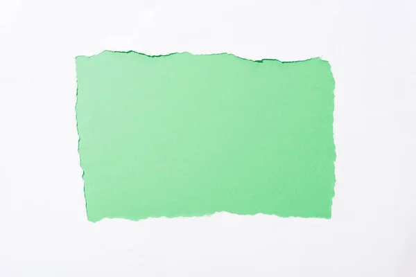Fundo colorido verde brilhante no buraco de papel rasgado branco — Fotografia de Stock