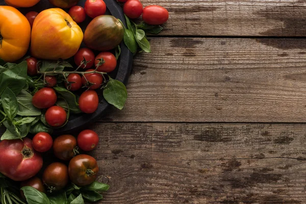 Vista superior de tomates e espinafre na panela de pizza na superfície de madeira — Fotografia de Stock