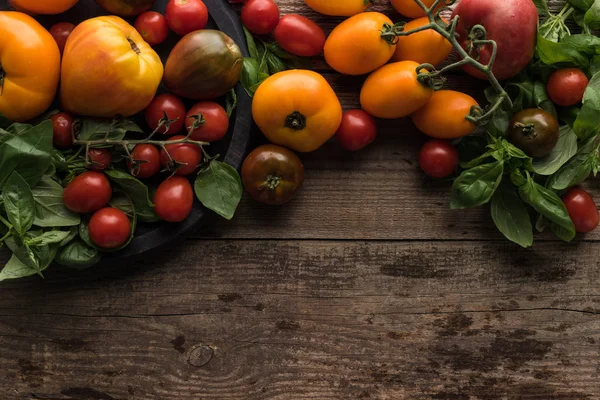 Vista superior de tomates espalhados perto de tomates e espinafre na panela de pizza na mesa de madeira — Fotografia de Stock
