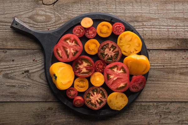 Vista superior da panela de pizza com tomates fatiados na mesa de madeira — Fotografia de Stock