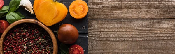 Panoramische Aufnahme eines schwarzen Tabletts mit Pfeffer in Schüssel, Chilischote, geschnittenen Tomaten und Knoblauch auf Holztisch — Stockfoto