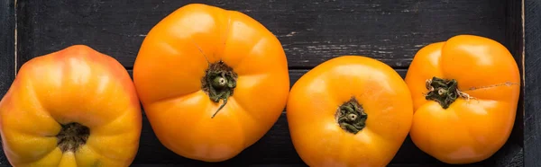 Plano panorámico de pocos tomates amarillos en caja negra de madera - foto de stock