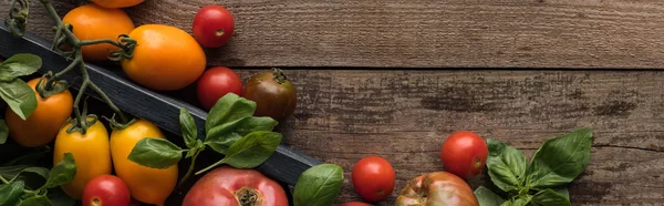 Panoramic shot of tomatoes and spinach in box on wooden table — Stock Photo