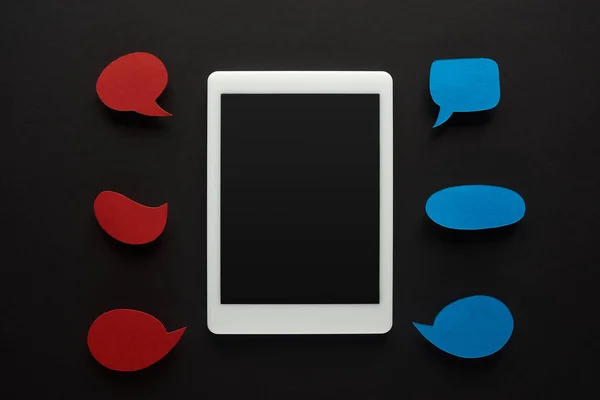 Top view of digital tablet on black background with empty red speech bubbles, cyberbullying concept — Stock Photo