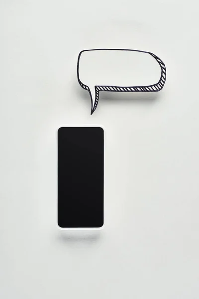 Vista superior del smartphone con pantalla en blanco sobre fondo blanco con burbuja de voz vacía, concepto de cyberbullying - foto de stock