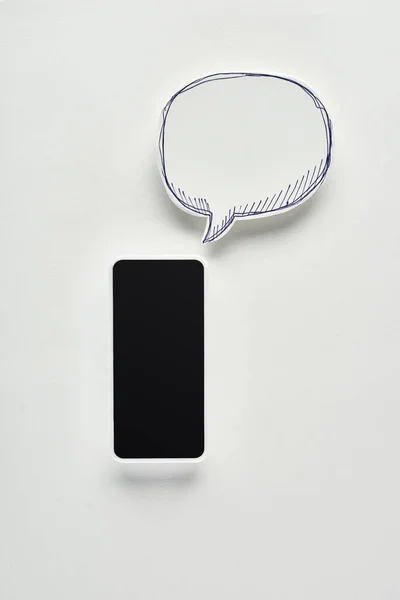 Top view of smartphone with blank screen on white background near empty speech bubble, cyberbullying concept — Stock Photo