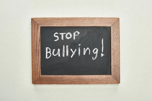 Vista superior de quadro-negro em quadro de madeira com stop bullying lettering no fundo cinza — Fotografia de Stock